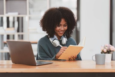 Young black African woman university student learning online using laptop computer. Smiling girl watch webinar or virtual education