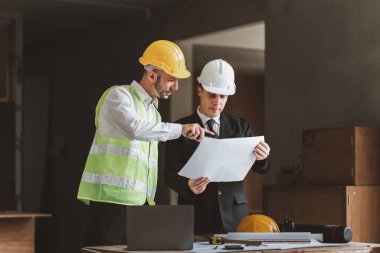 Mimarlık planının planlarıyla çalışan mimar takımı, bir inşaat projesi çizen mühendis, yeşil enerji konsepti.