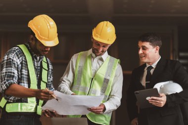 Mimarlık planının planlarıyla çalışan mimar takımı, bir inşaat projesi çizen mühendis, yeşil enerji konsepti.