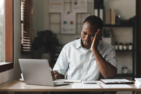 stock image Tired American African business man in stress works with many paperwork document. migraine attack. Freelance, work from home.