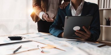 Fon yöneticileri takım danışmanlığı ve dijital tablet üzerinden yatırım borsası analizi hakkında tartışmalar.