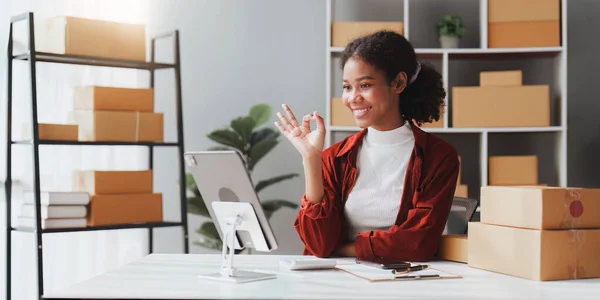 stock image American African entrepreneur smile and use a tablet to live stream. Successful SME entrepreneur concept.