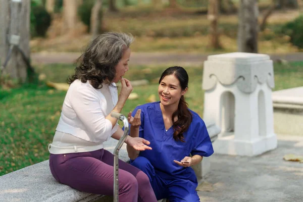 医療看護師 屋外で高齢女性との理学療法 看護師の手を握り 高齢女性を助ける — ストック写真