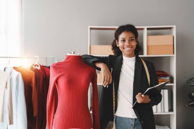 Stüdyoda dizüstü bilgisayarla çalışan Amerikalı Afrikalı moda tasarımcısı.