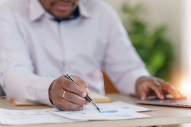 Gülümseyen Amerikalı Afrikalı finansal raporlar hazırlar ve yıllık rakamları inceler, karı analiz eder. Muhasebeci mali durumun durumunu kontrol ediyor.