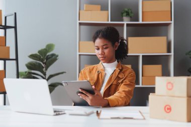 Amerikalı Afrikalı girişimci gülümseyip online siparişleri kontrol ediyor. Başarılı KME girişimci kavramı.