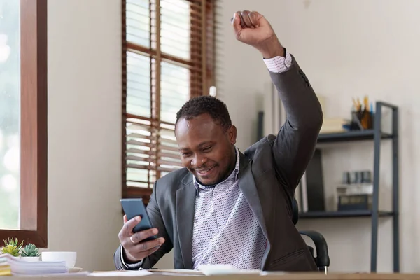 American African black man happy while reading email have a good news in smartphone. business finance and technology concept.
