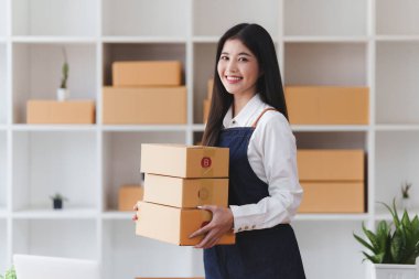 Küçük işletmeler KOBİ 'nin kadın girişimcileri, kutuları paketlemek, müşterilere satmak ve iş fikirlerini çevrimiçi olarak satmak için online siparişleri kontrol ediyorlar.