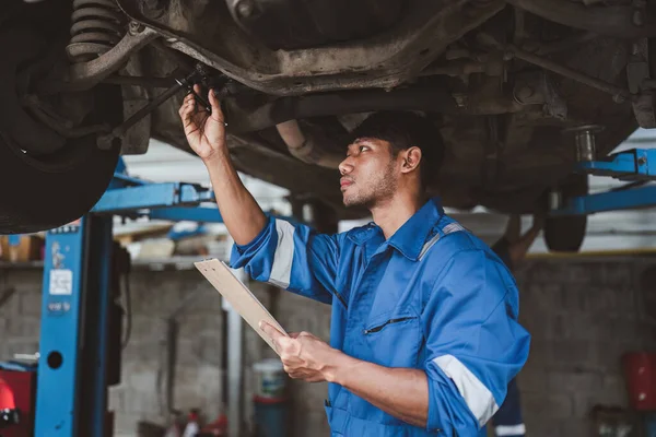 Otomobil tamirciliği ve servis müşteri hizmetleri uzmanı garajda araba tamir ediyor. otomobil konsepti.