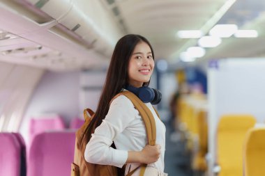 Uçak inerken sırt çantalı güzel Asyalı gezgin kadın. Seyahat, uçak konsepti.