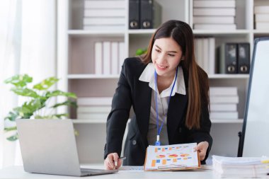 Asya İşletmeleri çalışanı ofiste analiz ve araştırma yapar, karları analiz eder. Muhasebeci mali durumun durumunu kontrol ediyor.