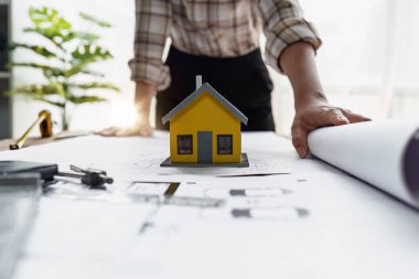 Mimarlık planının planları üzerinde çalışan mimar ve mühendis, bir inşaat projesi çizen mühendis, yeşil enerji kavramı.