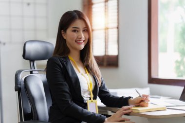 Asya İşletmeleri çalışanı ofiste analiz ve araştırma yapar, karları analiz eder. Muhasebeci mali durumun durumunu kontrol ediyor.