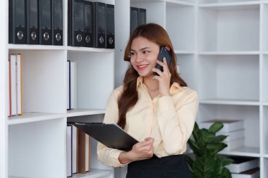 Profesyonel mali danışman, şirket muhasebecisi kadın müşteriyle telefonda konuşuyor. Faydaları analiz etmek, finansal keyfi sürmek.