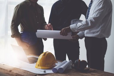 Mimarlık planının planları üzerinde çalışan mimar ve mühendis, bir inşaat projesi çizen mühendis, yeşil enerji kavramı.