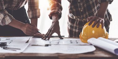 Mimarlık planının planları üzerinde çalışan mimar ve mühendis, bir inşaat projesi çizen mühendis, yeşil enerji kavramı.