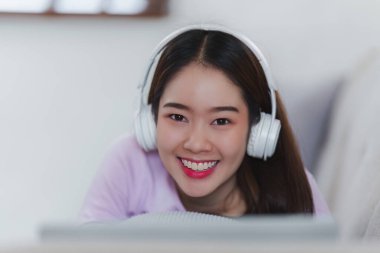 Çekici Asyalı kadın rahat oturma odasında dinleniyor ve cep telefonu kullanıyor, Rahat, Kanepe, Yaşam Tarzı.