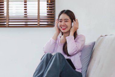 Çekici Asyalı kadın rahat oturma odasında dinleniyor ve dijital tablet kullanıyor, Rahat, Kanepe, Yaşam Tarzı.