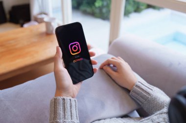 CHIANG MAI, THAILAND - 21 APR 2023: Instagram uygulaması ile Iphone 14 kullanan kadın eli, Instagram akıllı telefonlar için fotoğraf paylaşım uygulaması.