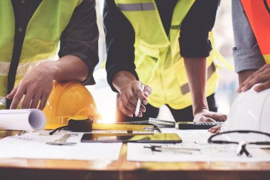 Mimarlık planının planları üzerinde çalışan mimar ve mühendis, bir inşaat projesi çizen mühendis, yeşil enerji kavramı.