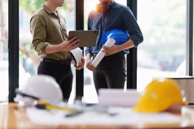 Mimarlık planının planları üzerinde çalışan mimar ve mühendis, bir inşaat projesi çizen mühendis, yeşil enerji kavramı.