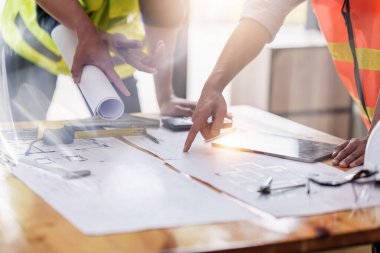 Mimarlık planının planları üzerinde çalışan mimar ve mühendis, bir inşaat projesi çizen mühendis, yeşil enerji kavramı.