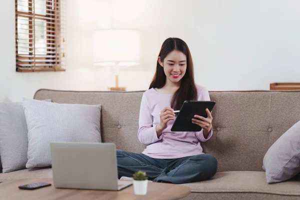 stock image Attractive Asian woman resting comfortable living room and using digital tablet, Relax, Sofa, Lifestyle.