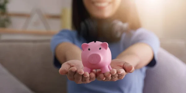 年轻的亚洲女人手把硬币放在粉红色的储蓄罐里存钱 退休基金 财务会计 — 图库照片