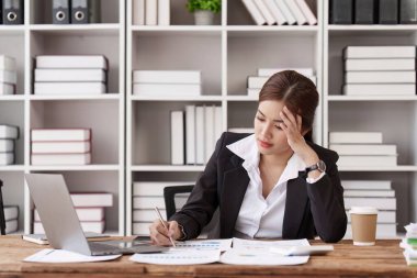 Çalışan kendini yorgun hissediyor. Ofisteki işi yüzünden stresli. Çalışan üzgün kadın fazla mesai yapıyor..