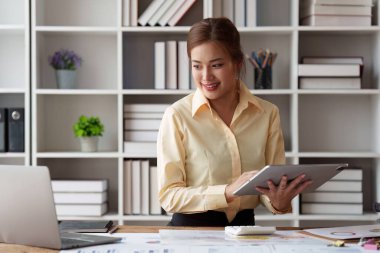 Tablet üzerinde çalışan ve belge, vergi, takas, muhasebe ve mali danışman konsepti üzerinde çalışan muhasebeci Asyalı kadın.