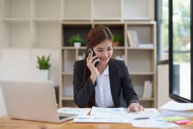 Güzel bir iş kadını cep telefonuyla konuşuyor. Yönetim, planlama ve ağ arama kavramı.