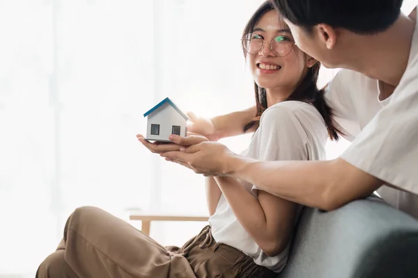 新しい家のための不動産を購入するお金の富を節約するために家の銀行を保持する幸せなアジアの家族の若いカップル 財務計画 ビジネスファイナンスの概念 — ストック写真