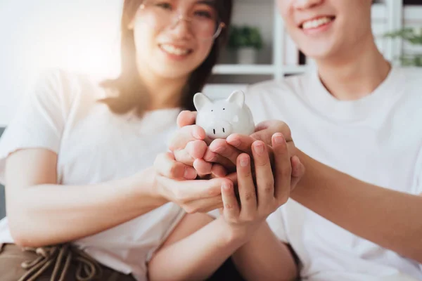 幸せなアジアの家族の若いカップルは 新しい家のための不動産を購入するお金の富を節約するために貯金するために貯金豚銀行を保持 財務計画 ビジネスファイナンスの概念 — ストック写真