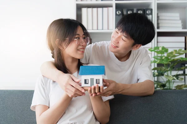 新しい家のための不動産を購入するお金の富を節約するために家の銀行を保持する幸せなアジアの家族の若いカップル 財務計画 ビジネスファイナンスの概念 — ストック写真