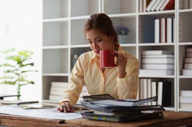 Bilgisayarda çalışan ve belge, vergi, takas, muhasebe ve mali danışman konsepti üzerinde çalışan Asyalı muhasebeci kadın..