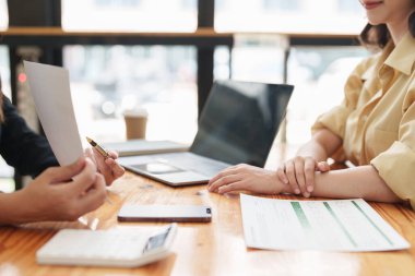 Asya iş adamları ofiste analiz ve araştırma yapar, karları analiz eder. Muhasebeci mali durumun durumunu kontrol ediyor.