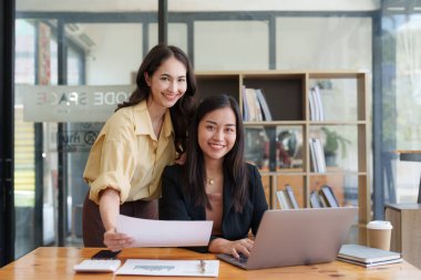 Asya iş adamları ofiste analiz ve araştırma yapar, karları analiz eder. Muhasebeci mali durumun durumunu kontrol ediyor.