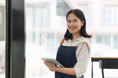Cafe 'de gülümseyen Asyalı kafe sahibi ya da kahveci. Kadın küçük işletme sahibi yiyecek ve içecek..