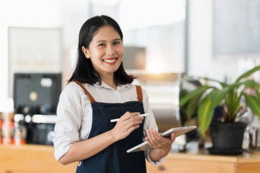 Cafe 'de gülümseyen Asyalı kafe sahibi ya da kahveci. Kadın küçük işletme sahibi yiyecek ve içecek..