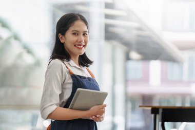 Cafe 'de gülümseyen Asyalı kafe sahibi ya da kahveci. Kadın küçük işletme sahibi yiyecek ve içecek..