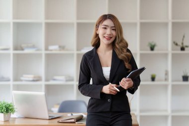 Dizüstü bilgisayarda çalışan ve belge, vergi, takas, araştırma, muhasebe ve mali danışman konsepti üzerinde çalışan muhasebeci kadın.