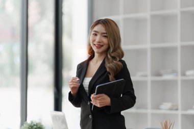 Dizüstü bilgisayarda çalışan ve belge, vergi, takas, araştırma, muhasebe ve mali danışman konsepti üzerinde çalışan muhasebeci kadın.