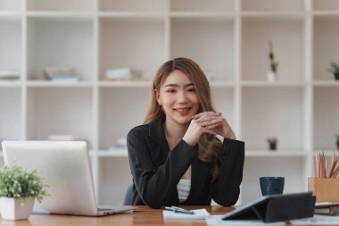 Dizüstü bilgisayarda çalışan ve belge, vergi, takas, araştırma, muhasebe ve mali danışman konsepti üzerinde çalışan muhasebeci kadın.