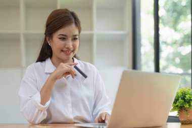 Çevrimiçi mağaza simgesi, internetten alışveriş, sanal ekranda elleri dizüstü bilgisayar uygulamasında olan Asyalı kadın.