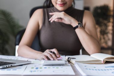 Dizüstü bilgisayarda çalışan ve belge, vergi, takas, araştırma, muhasebe ve mali danışman konsepti üzerinde çalışan muhasebeci kadın.