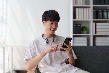 Çevrimiçi mağaza, internet alışverişi, Asyalı adamın sanal ekranda akıllı telefon uygulamasını seçmesi.