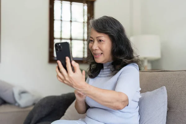 Äldre Asiatiska Kvinnor Som Använder Sociala Medier Och Vardagsrum Video — Stockfoto