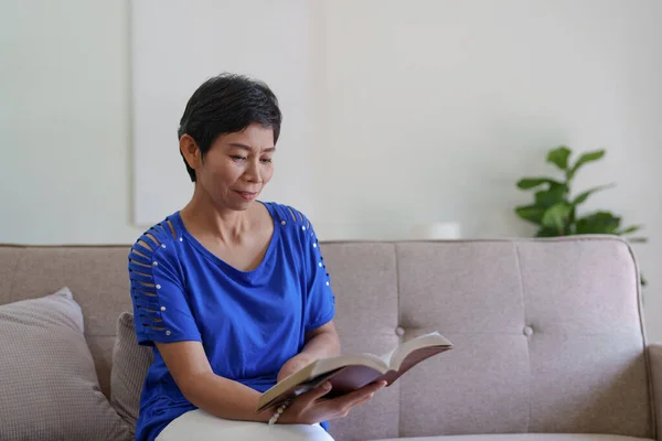 Glada Asiatiska Äldre Kvinna Läser Bok Och Sitter Soffan Hemma — Stockfoto