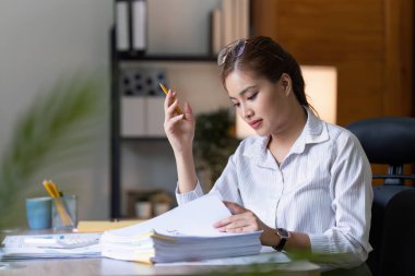 Dizüstü bilgisayarda çalışan ve belge, vergi, takas, araştırma, muhasebe ve mali danışman konsepti üzerinde çalışan muhasebeci kadın.