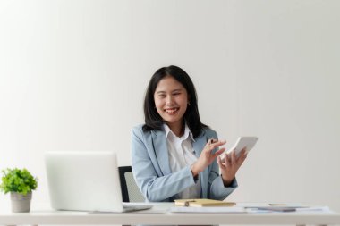 Gülümseyen Asyalı Muhasebeci mali raporu analiz eder ve yıllık rakamları inceler, karı analiz eder.